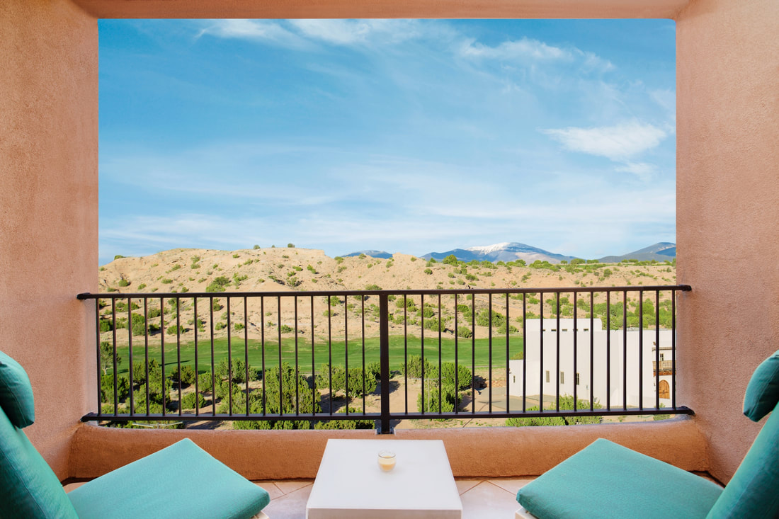Chairs on balcony overlooking golf course and desert